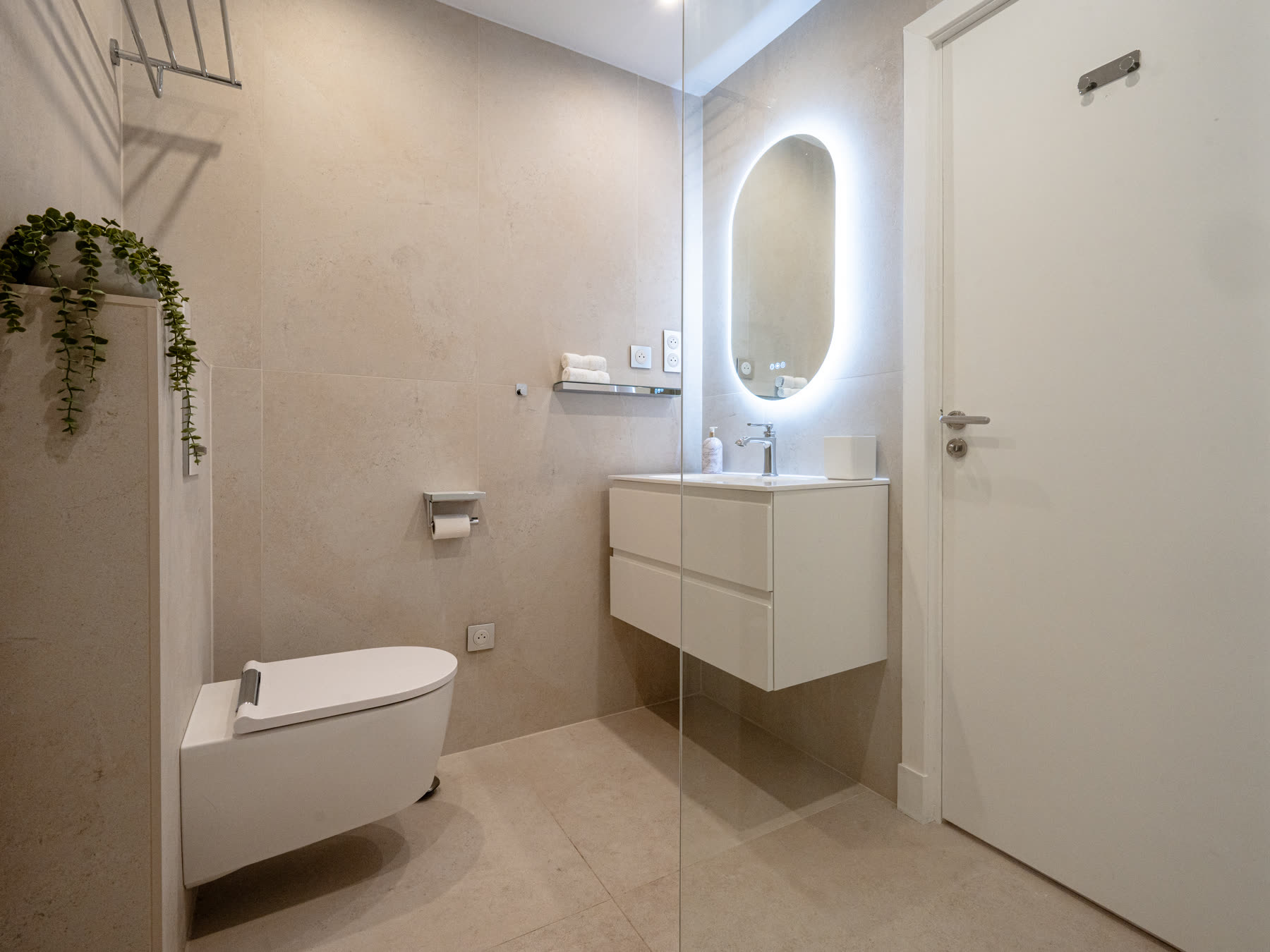 Contemporary bathroom with backlit mirror and walk-in shower