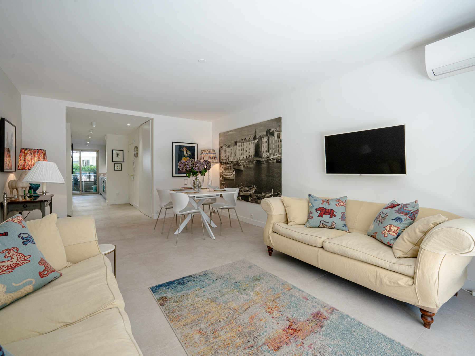 Living room with cream sofas and harbour artwork