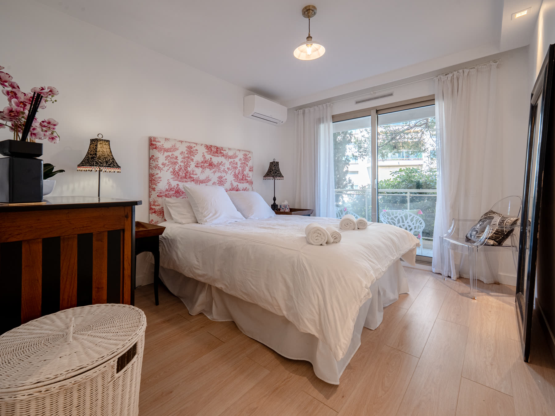 Second bedroom with pink toile headboard and garden view